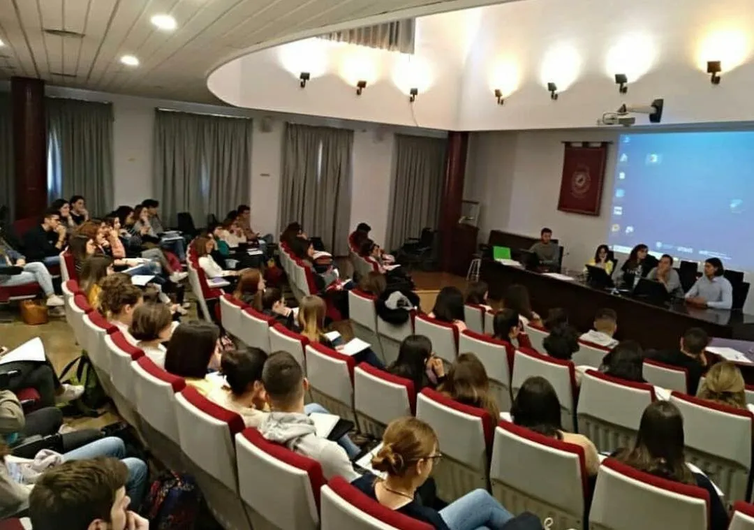 Auditorio universitario lleno de estudiantes durante una ponencia