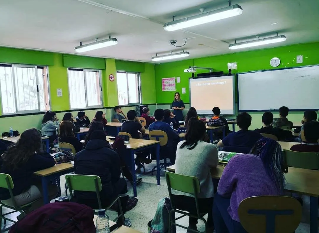 Sonia Ramírez dando una charla a estudiantes en un aula de paredes verdes
